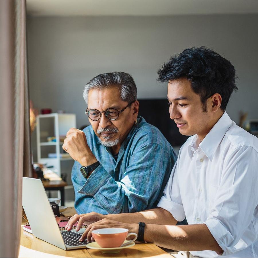 a few men looking at a laptop